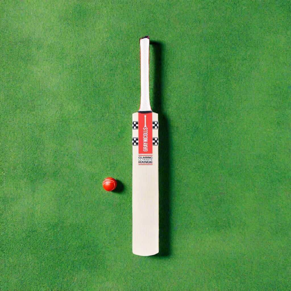 A standing cricket bat with a white grip and red and black branding, predominantly beige in color.