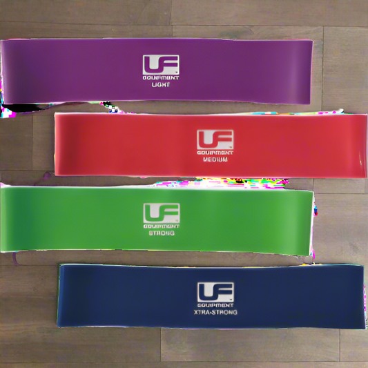 A set of four Urban Fitness resistance bands in different colors: purple, red, green, and blue, each with the brand logo printed on the surface.