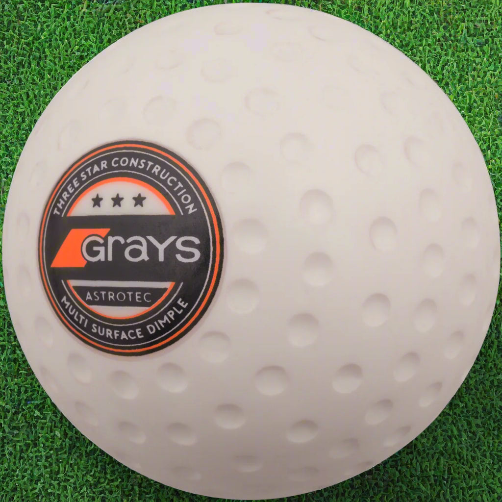 A white Grays AstroTec hockey ball with dimple pattern.