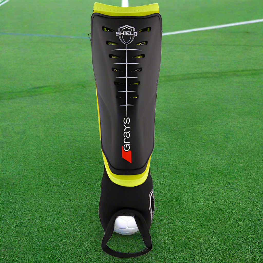 A black and yellow 'football-style' shinguard with high impact plastic shell and ankle disks, branded with the name 'grays'.