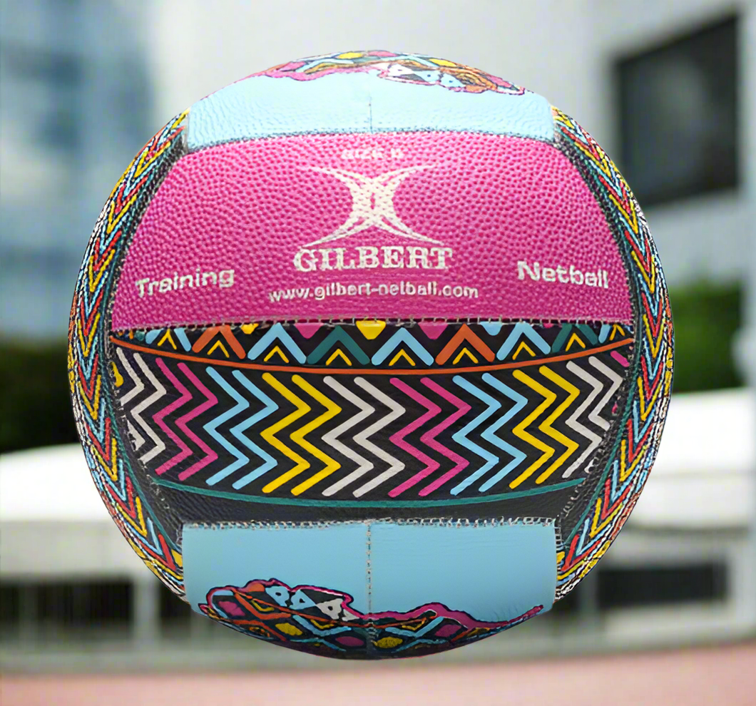 A Gilbert Signature Netball with a multicolored pattern, predominantly pink and blue, with the brand's logo and text indicating it is a training netball.