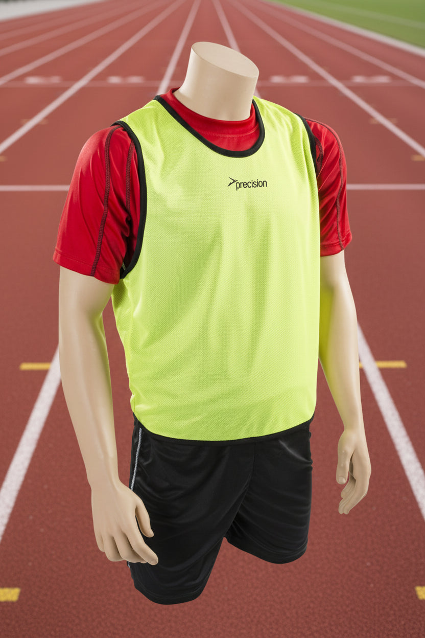 A mesh training bib in yellow with black trim and a Precision logo on the chest area, displayed on a mannequin with black shorts.