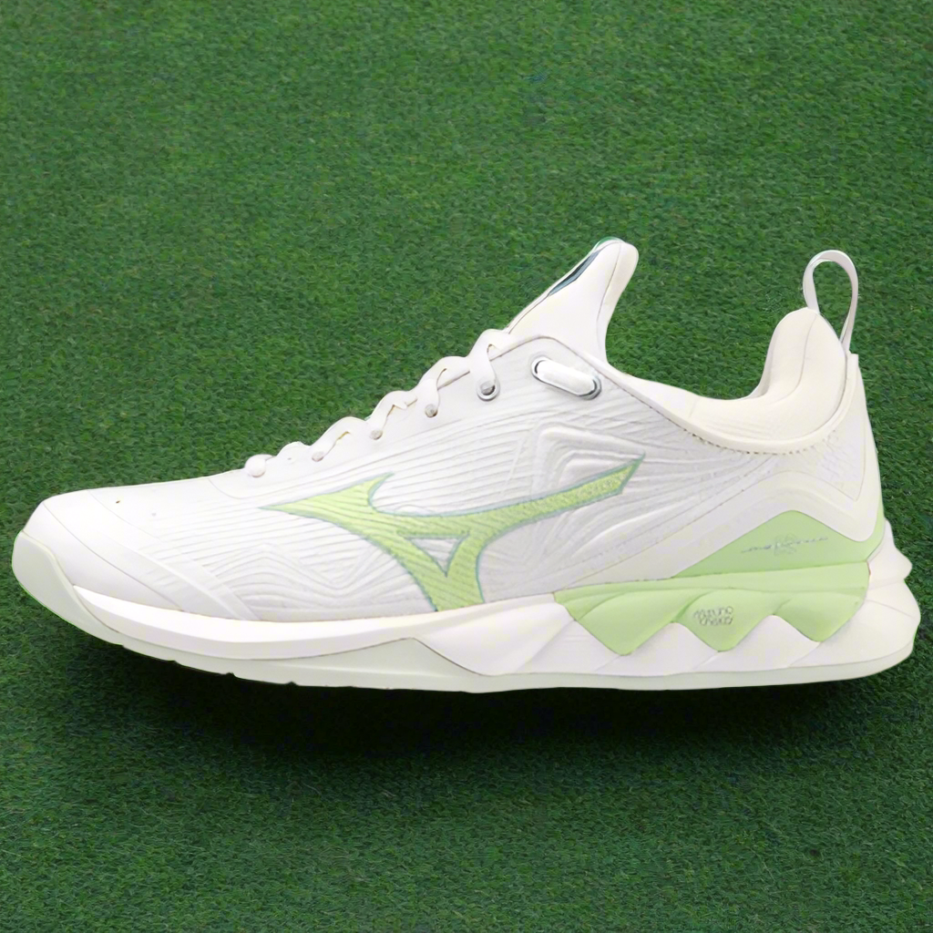 A pair of Mizuno Wave Luminous 2 Netball Shoes in white with green accents, featuring a midsole with visible branding and a distinctive design on the side.