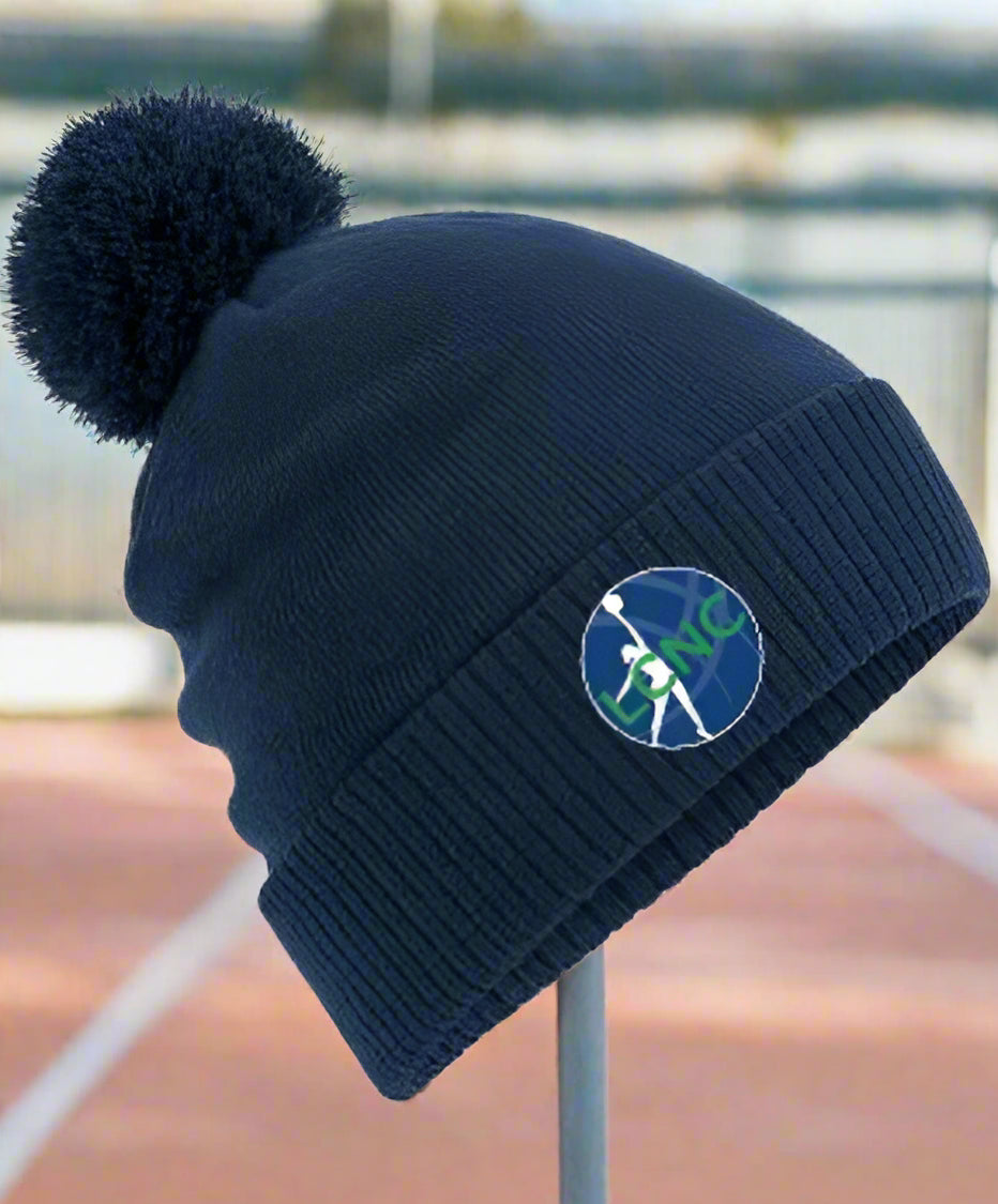 A navy blue beanie with a pom-pom on top, featuring an embroidered logo on the front.