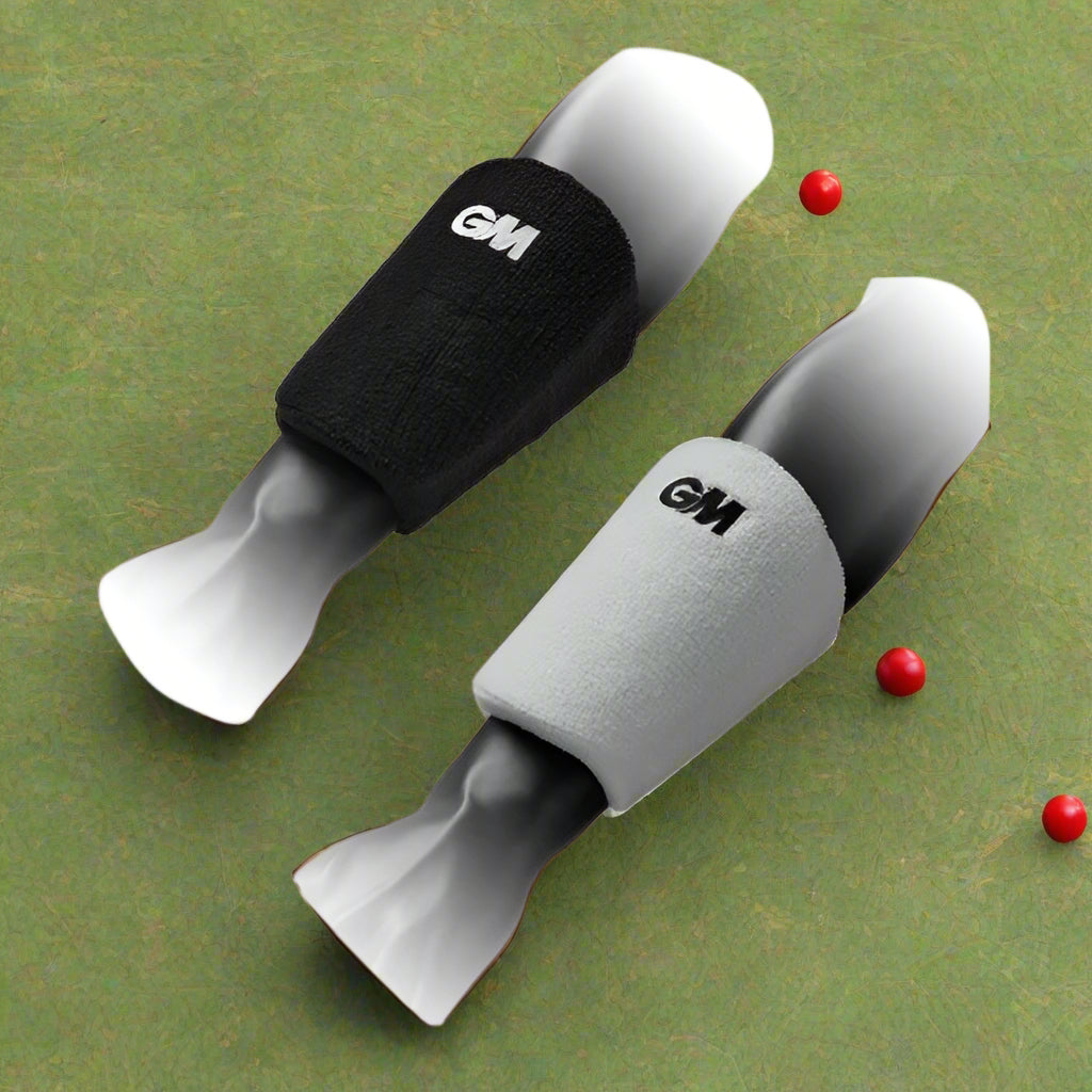 A pair of wrist guards, one in black and one in gray, featuring a pre-curved shape and a soft touch toweling sweatband.