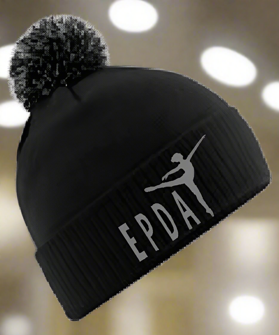 A black bobble hat with a pom pom, featuring the En Pointe Dance Academy logo embroidered on the front.