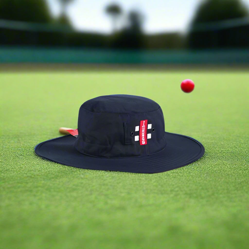 A navy Gray Nicolls sun hat with a red and white stripe detail on the front.