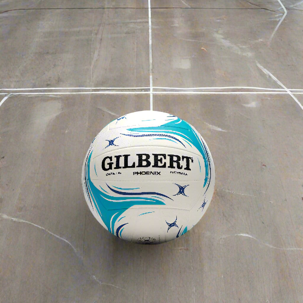 A Gilbert Phoenix netball with a predominantly white surface featuring blue and red patterned design, on a plain background.