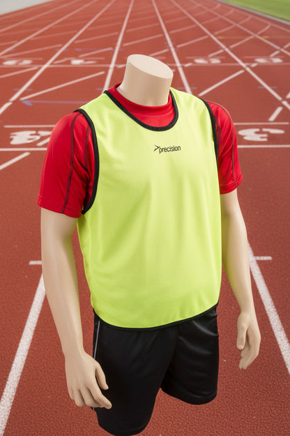 A mesh training bib in yellow with black trim and a Precision logo on the chest area, displayed on a mannequin with black shorts.