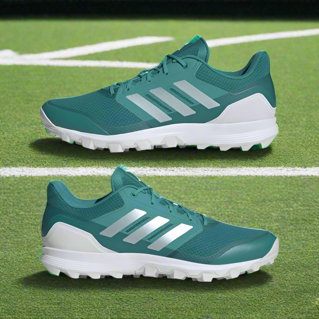 Teal running shoes with white soles and stripes on a white background