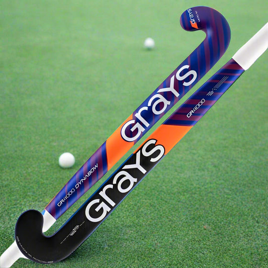 A field hockey stick with a blue and white color scheme, featuring the brand name 'grays' in orange letters.